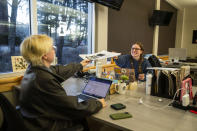 Executive Editor Sabine Martin, right, passes a drafted paper to Managing Editor Parker Jones in The Daily Iowan newsroom, Feb. 29, 2024, in Iowa City, Iowa. (Emily Nyberg/The Daily Iowan via AP)