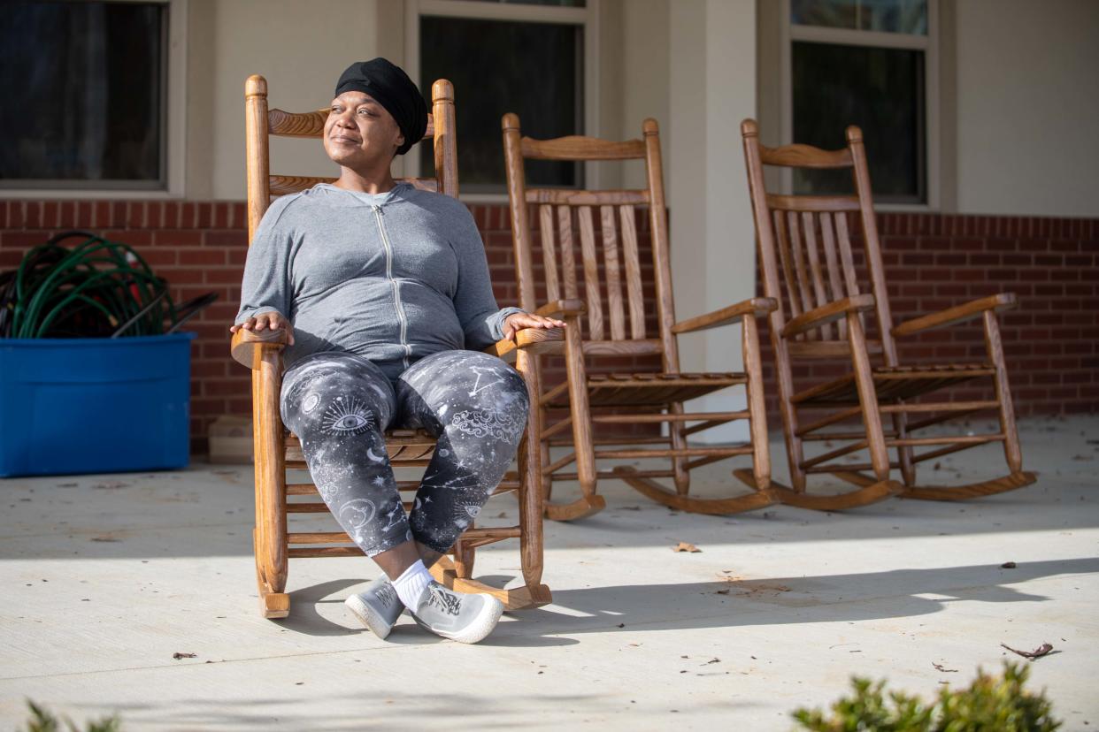 Krystle Terry sits on a rocking chair on the patio of The Dream Center in Jackson, Tenn., on Thursday, Dec. 21, 2023. Terry, alongside her two children, left her home following a domestic violence-charged relationship.