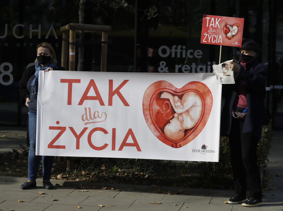 Anti-abortion activists attend a protest in front of Poland's constitutional court, in Warsaw, Poland, Thursday, Oct. 22, 2020. Poland’s top court has ruled that a law allowing abortion of fetuses with congenital defects is unconstitutional. The decision by the country’s Constitutional Court effectively bans terminating pregnancies in cases where birth defects are found and will further limit access to abortions in Poland. Sign reads in Polish "yes to life". (AP Photo/Czarek Sokolowski)