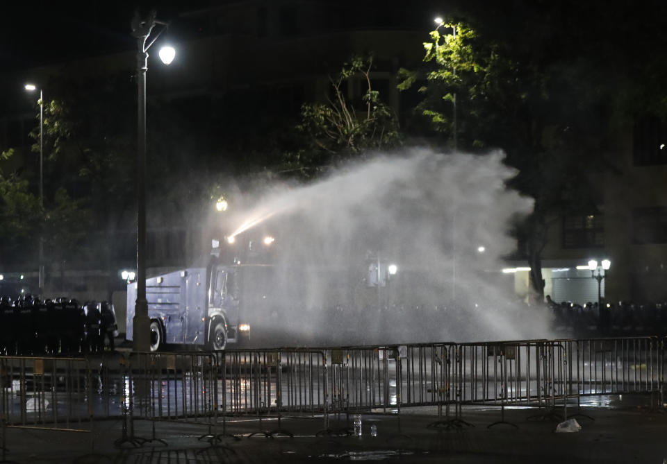 Police use water cannons to disperse protesters Saturday, March 20, 2021 in Bangkok, Thailand. Thailand's student-led pro-democracy movement is holding a rally in the Thai capital, seeking to press demands that include freedom for their leaders, who are being held without bail on charges of defaming the monarchy. (AP Photo/Sakchai Lalit)