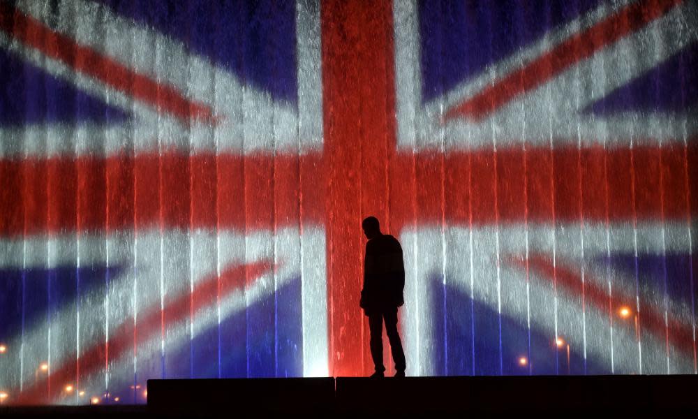 A man stands in front of a fountain illuminated with the colours of the UK flag in Zagreb.