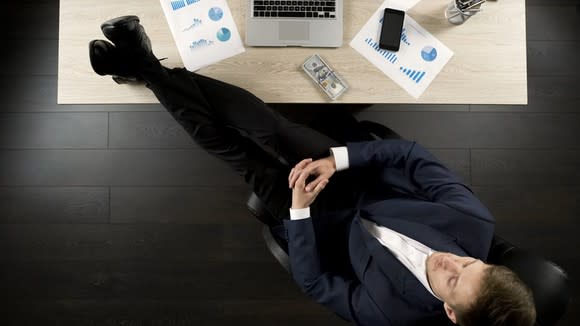 A businessman with his feet on his desk.