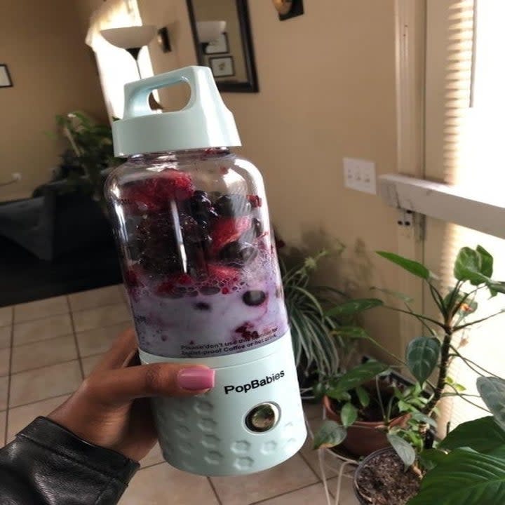 A reviewer photo of the personal blender with fruit inside before blending