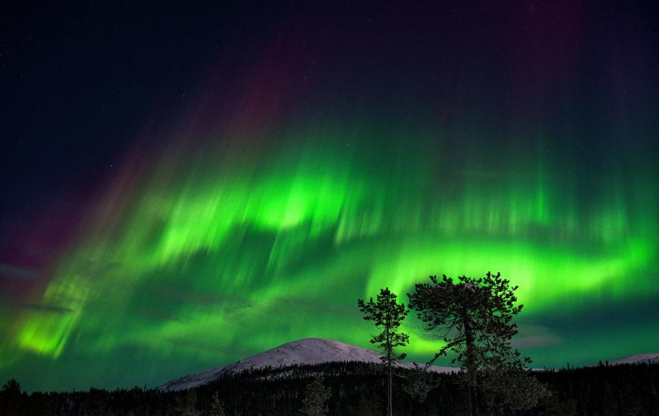An aurora borealis, also known as northern lights, illuminates the night sky above the Kellostapuli Fell in Kolari, Finnish Lapland, early on Jan. 15, 2022.  / Credit: IRENE STACHON/Lehtikuva/AFP via Getty Images