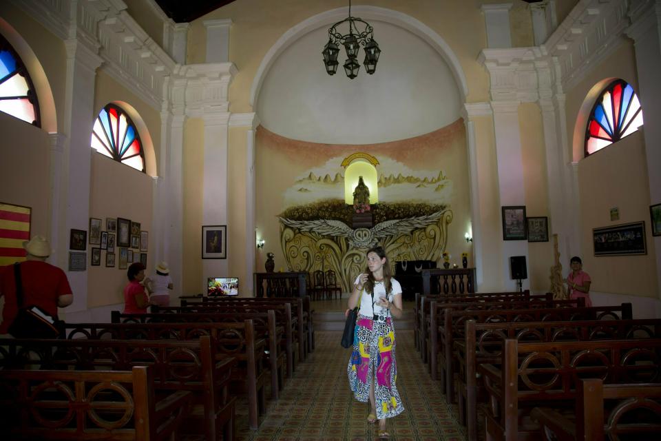 In this May 11, 2019 photo, a tourist walks through a Spanish-style church at the Hermitage of Monserrate, in Matanzas, Cuba. In total, Cuba drew 4.7 million tourists in 2018, a 1.3% rise over the previous year that puts its latest goal of 5 million within reach. (AP Photo/Ismael Francisco)