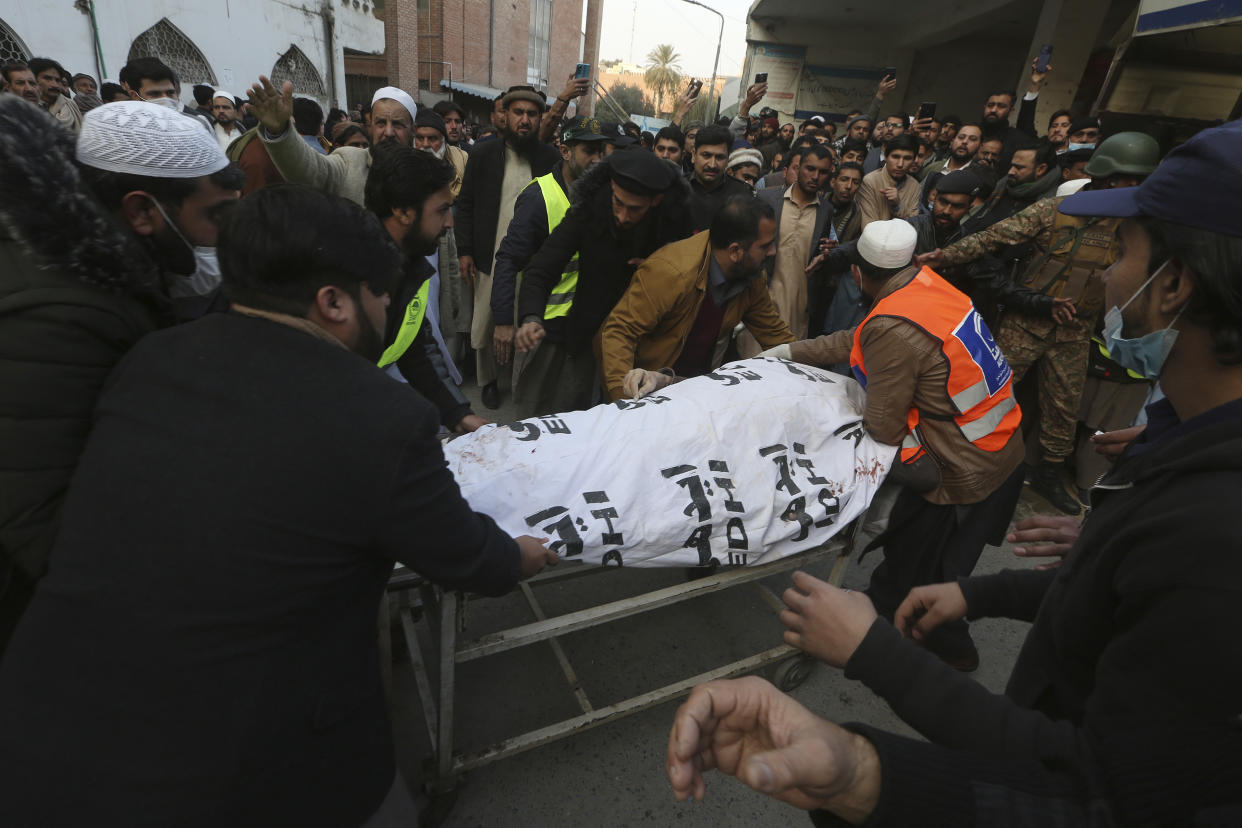 People carry a body of their relative, killed in the suicide bombing inside a mosque, after collecting from a hospital, in Peshawar, Pakistan, Monday, Jan. 30, 2023. A suicide bomber struck Monday inside a mosque in the northwestern Pakistani city of Peshawar, killing multiple people and wounding scores of worshippers, officials said. (AP Photo/Muhammad Sajjad)