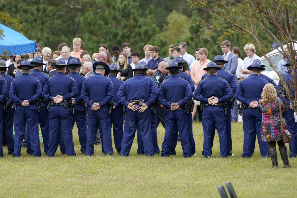 Troopers stand at ease with their hands folded, across from some of the family and friends that witnessed the burial services for Louisiana State Police Master Trooper Chris Hollingsworth, Friday, Sept. 25, 2020 in West Monroe, La. Hollingsworth was killed in a car crash hours after he was told he would be fired for his role in the in-custody death of a Black man. (AP Photo/Rogelio V. Solis)