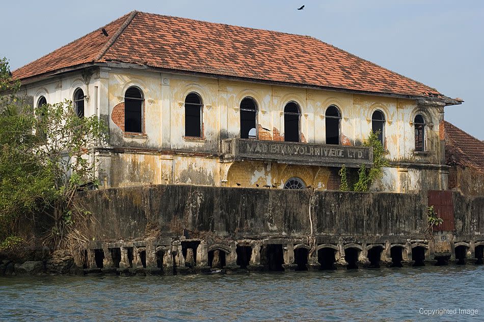 <p><b>Abandoned building along the Cochin waterfront.</b><br><em>©Donald Fels / Published in ‘Mosques of Cochin’ by Patricia Tusa Fels</em><br> Cochin is sited on a peninsula, with the Arabian Sea to the west, a sheltered waterway and port to the east, and the river channel’s opening to the sea at the north. The natural harbour connected inland backwaters and global sea-lanes, offering a protected landing for generations of overseas traders and local merchants. As peninsular Cochin slipped into a daydream, the mainland area of Ernakulam and the new port of Willingdon Island became the centres of modern industry.</p>