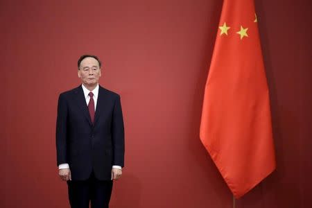 China's Politburo Standing Committee member Wang Qishan stands next to a Chinese flag at the Great Hall of the People in Beijing, China, September 2, 2015. REUTERS/Jason Lee/Files