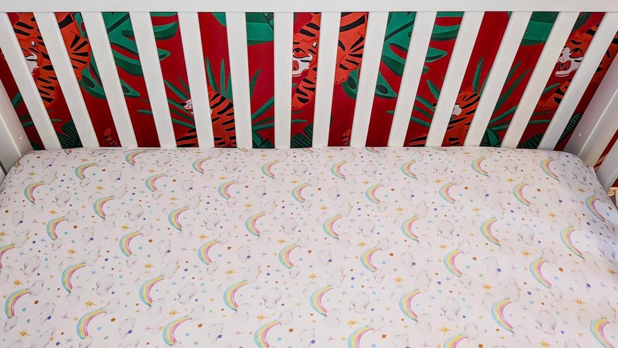 a baby crib with a colorful sheet