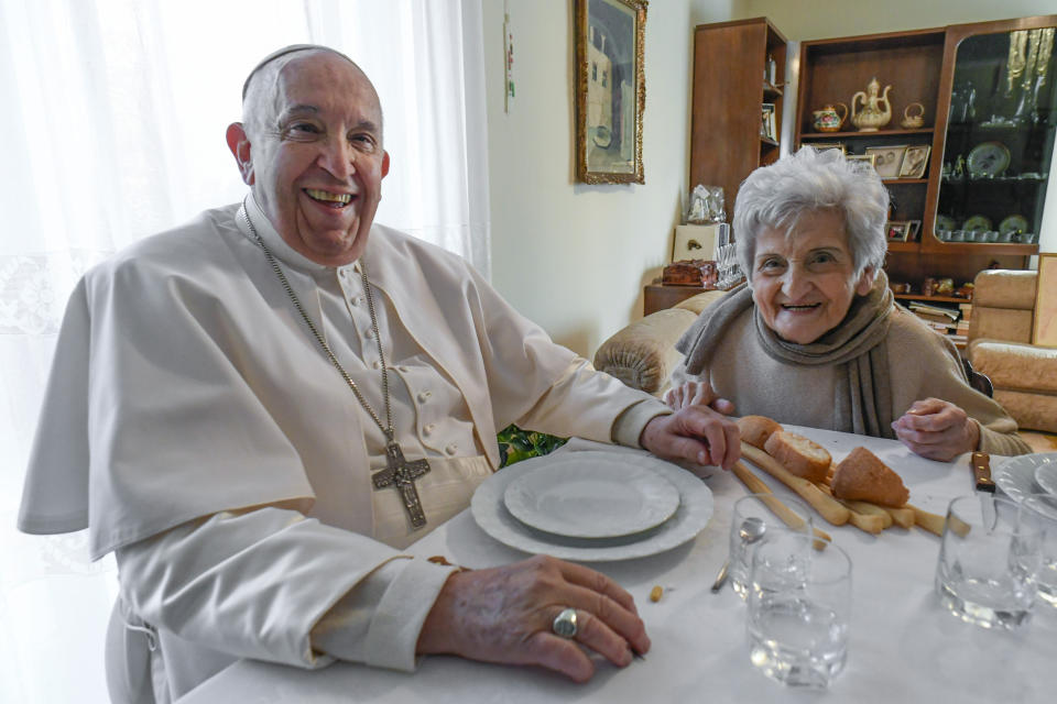 In this image made available by Vatican Media, Pope Francis sits for lunch in the home of a cousin, Carla Rabezzana, right, in the town of Portacomaro, about 10 kilometers (six miles) east of Asti, northern Italy, Saturday, Nov. 19, 2022. Rabezzana told local media that she and the pope kept up their connections over the years as he would stay with her while visiting Turin, where she long lived, before he became pope. (Vatican Media via AP)