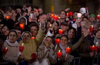 Faithful attend the Via Crucis (Way of the Cross) torchlight procession celebrated by Pope Francis in front of the Colosseum on Good Friday in Rome, Friday, April 18, 2014. (AP Photo/Gregorio Borgia)