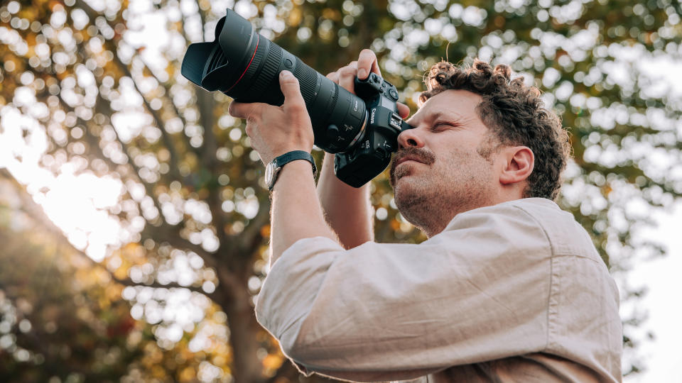 A man holding a Canon RF 24-105mm f/2.8 IS USM Z