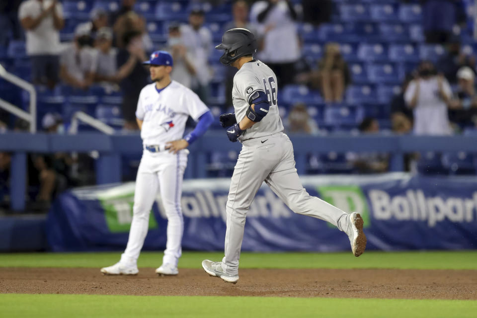 New York Yankees' Kyle Higashioka rounds the bases after his home run as Toronto Blue Jays third baseman Cavan Biggio looks on during the eighth inning of a baseball game Monday, April 12, 2021, in Dunedin, Fla. (AP Photo/Mike Carlson)