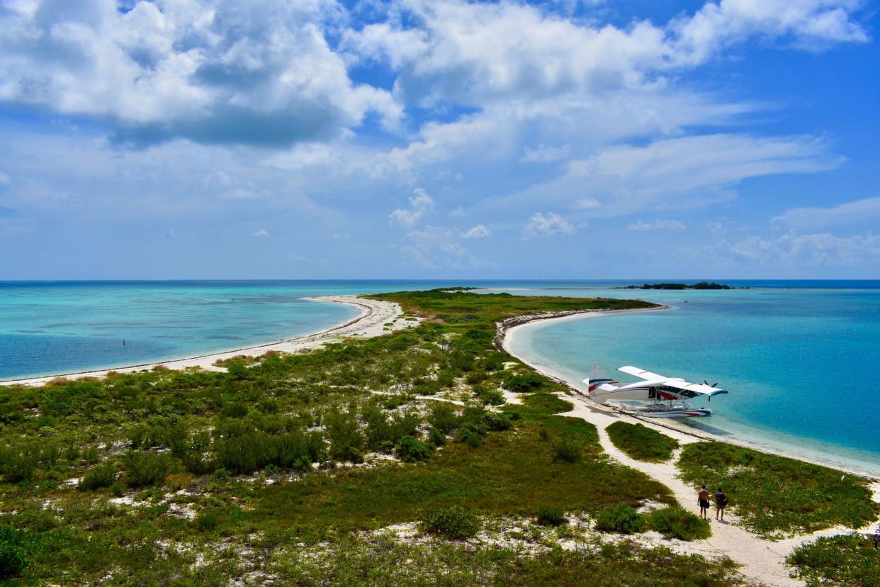 two people walking in the distance toward a seaplane, Dry Tortugas National Park