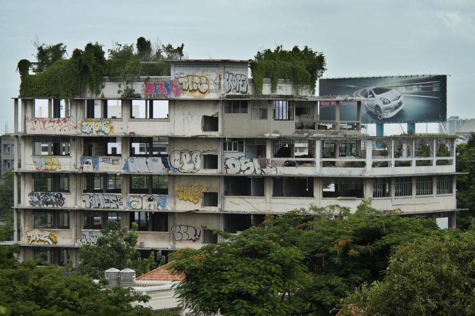 <p>Grass and graffiti have overtaken an uninhabited apartment building.</p>