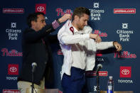 Philadelphia Phillies general manager Sam Fuld, left, helps newly acquired shortstop Trea Turner with his jersey during his introductory news conference, Thursday, Dec. 8, 2022, in Philadelphia. (AP Photo/Matt Slocum)