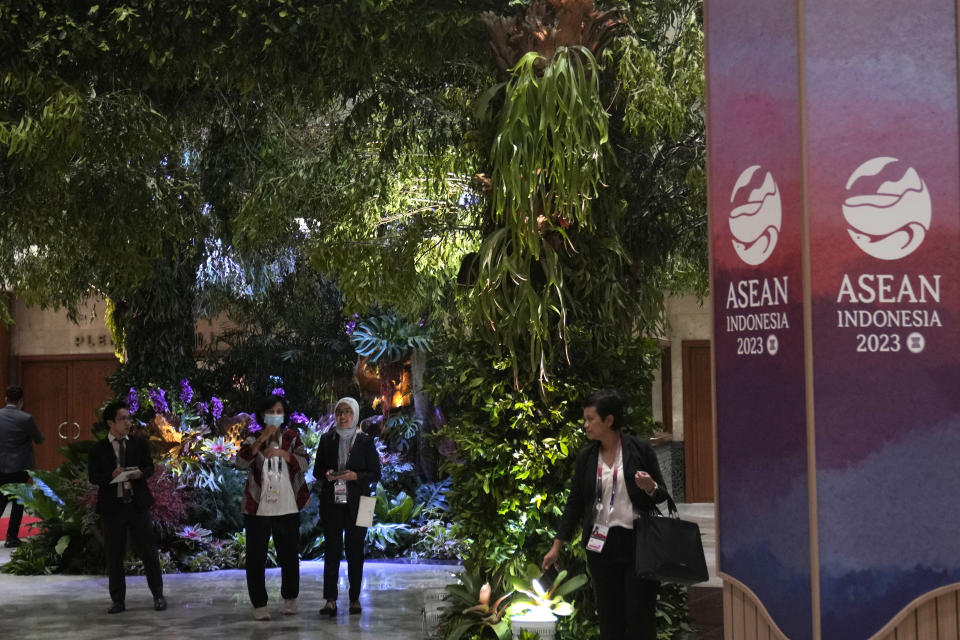 Members of the delegate stand under the plants used to decorate the Jakarta Convention Center, the venue of the Association of Southeast Asian Nations (ASEAN) Summit in Jakarta, Indonesia, Tuesday, Sept. 5, 2023. Indonesian President Joko Widodo will welcome fellow Asian and world leaders with a captivating jungle scene of a two-story waterfall, wild orchids and even an orangutan perched up a tree. (AP Photo/Dita Alangkara, Pool)