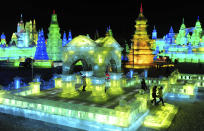 Tourists visit ice sculptures during the lights testing period of the 13th Harbin Ice and Snow World in Harbin, Heilongjiang province December 25, 2011. The Harbin International Ice and Snow Festival will be officially launched on January 5, 2012. Picture taken December 25, 2011. REUTERS/Sheng Li (CHINA - Tags: ENVIRONMENT SOCIETY TRAVEL)