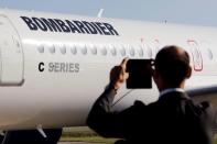 A man takes a picture of a Bombardier CSeries aircraft during a news conference to announce a partnership between Airbus and Bombardier on the C Series aircraft programme, in Colomiers near Toulouse, France, October 17, 2017. REUTERS/Regis Duvignau