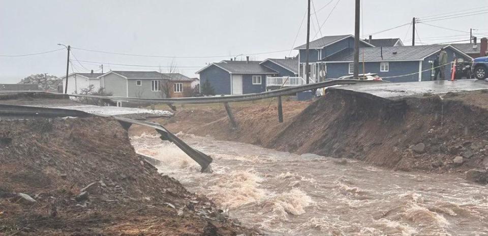 Route 460 has been completely washed out, with loose culverts bashing through the railing as they washed away, close to occupied homes. (Department of Transportation and Infrastructure - image credit)