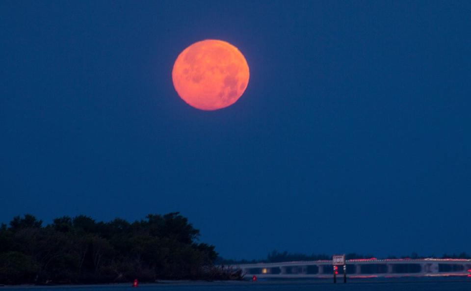 The almost full moon sets over Fort Myers Beach on Monday, April 26, 2021. 