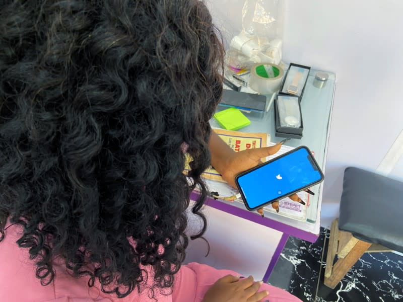 Lagos based entreprenuer Ogechi Egemonu opens the Twitter app on a smart phone at her office in Lagos