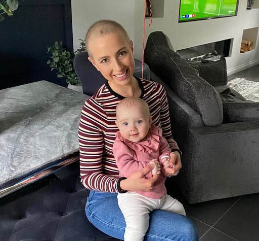 Kirsty Axworthy without her wig sitting down with her baby Elle while she was undergoing treatment. 