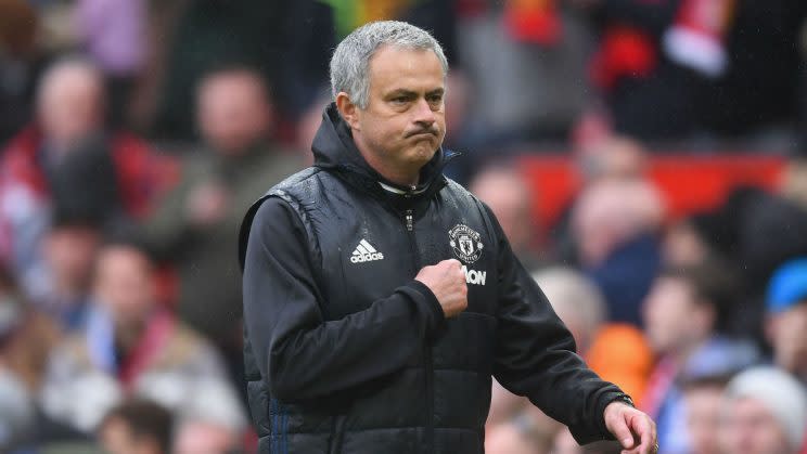 Jose Mourinho points to his badge as he walks off Old Trafford after defeating Chelsea 2-0