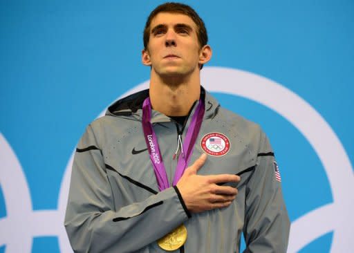 Gold medalist US swimmer Michael Phelps listens to his national anthem on the podium after winning the men's 200m individual medley swimming event at the London 2012 Olympic Games in London