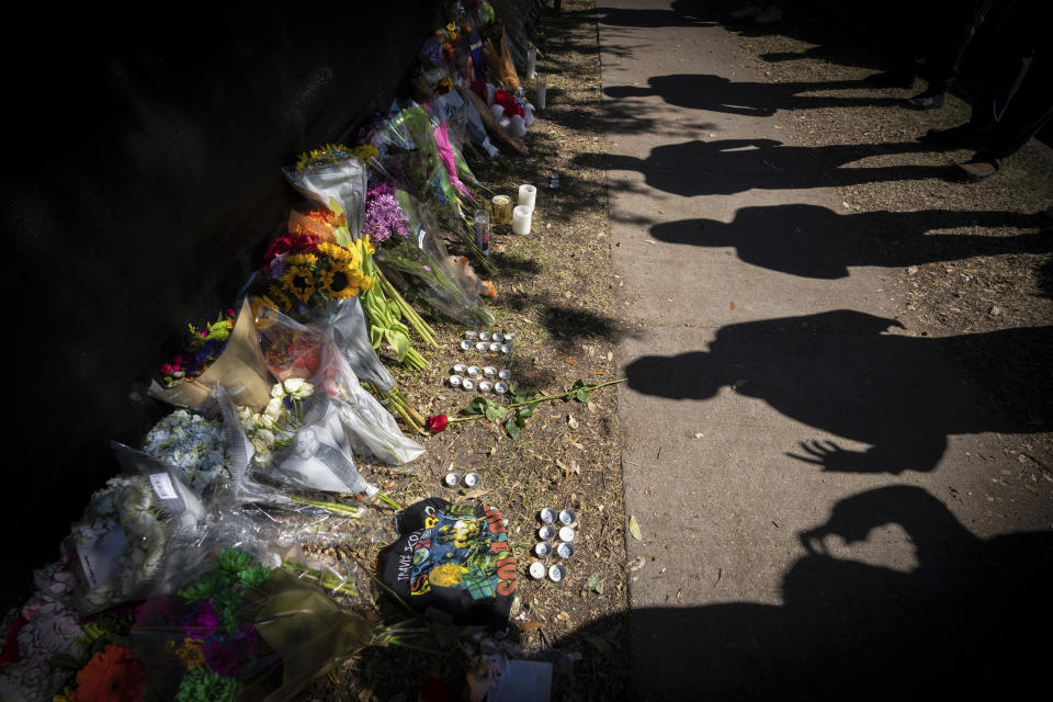 Sombras de visitantes a una ofrenda para conmemorar a las víctimas del festival Astroworld en Houston el domingo 7 de noviembr de 2021. (Foto AP/Robert Bumsted)