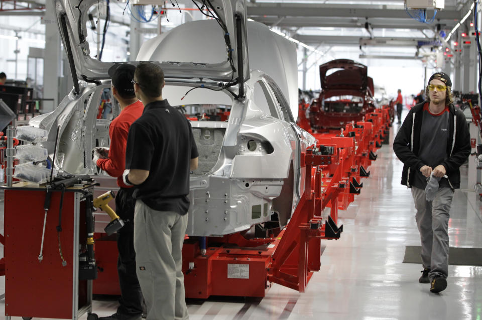 Assembly workers put together a Tesla Model S at the Tesla factory in Fremont, Calif., Friday, June 22, 2012. The first Model S sedan car will be rolling off the assembly line on Friday. (AP Photo/Paul Sakuma)