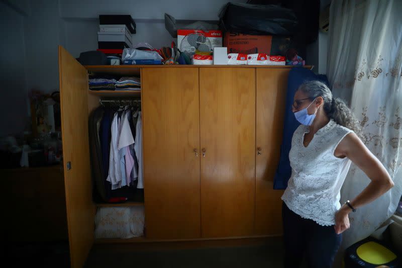 Ibtissam Hasrouty looks at clothes in the closet that belongs to her husband Ghassan Hasrouty, a missing silo employee, following Tuesday's blast in Beirut's port area
