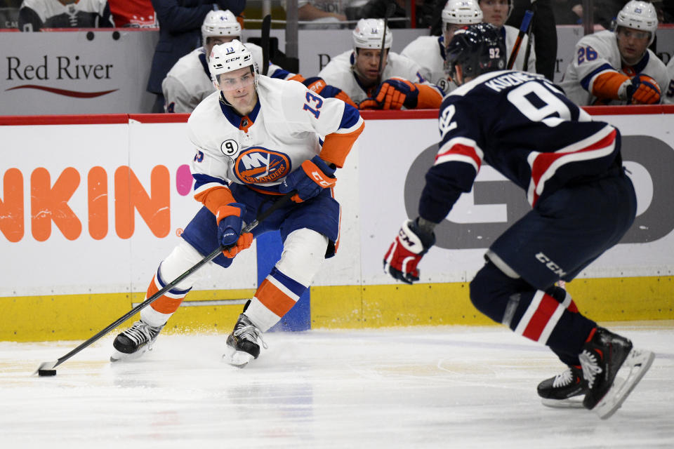 New York Islanders center Mathew Barzal (13) skates with the puck against Washington Capitals center Evgeny Kuznetsov (92) during the second period of an NHL hockey game, Tuesday, April 26, 2022, in Washington. (AP Photo/Nick Wass)