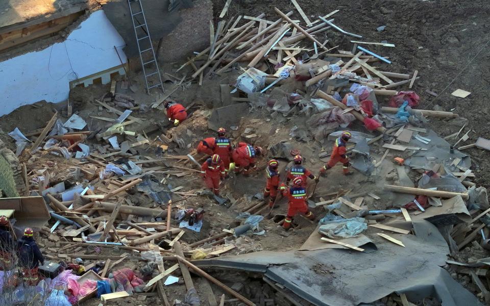 Rescuers search a collapsed building in Caotan village