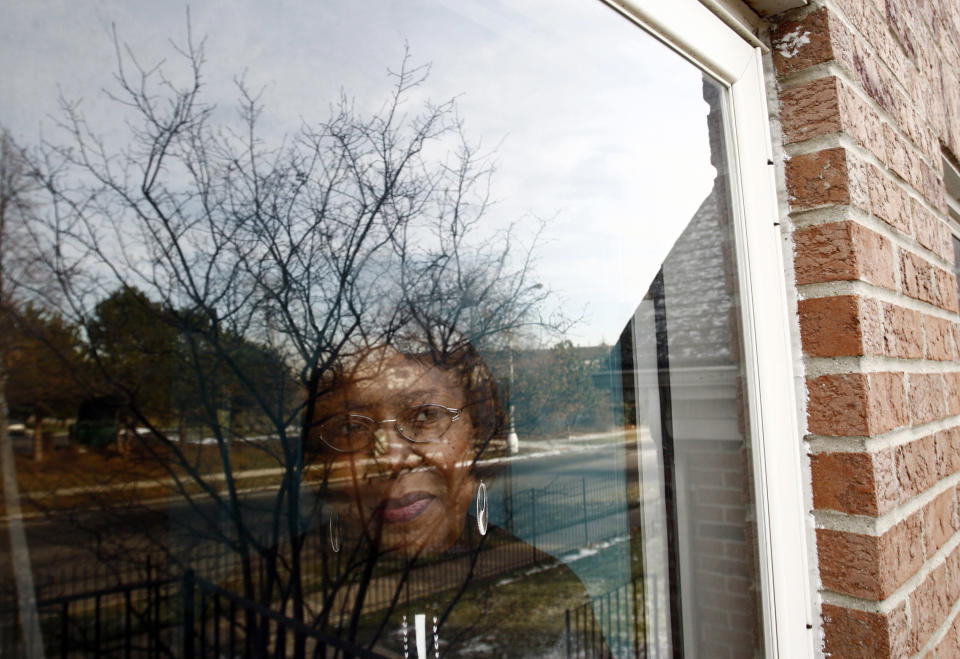 Lorene Parker watches outside through a window at her house, which is in foreclosure in Detroit, Michigan December 11, 2008. Parker of Detroit fell behind on her mortgage with Bank of America when she had large medical bills from heart and liver double transplant. REUTERS/Carlos Barria