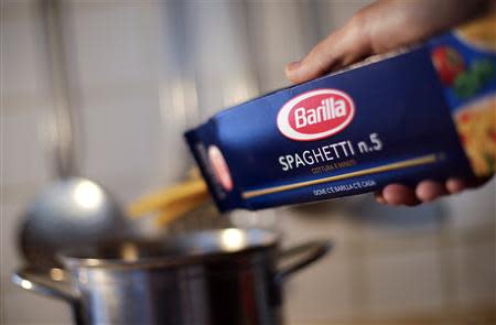 A man throws Barilla spaghetti into boiling water as he cooks at his home in Rome September 27, 2013. REUTERS/Max Rossi