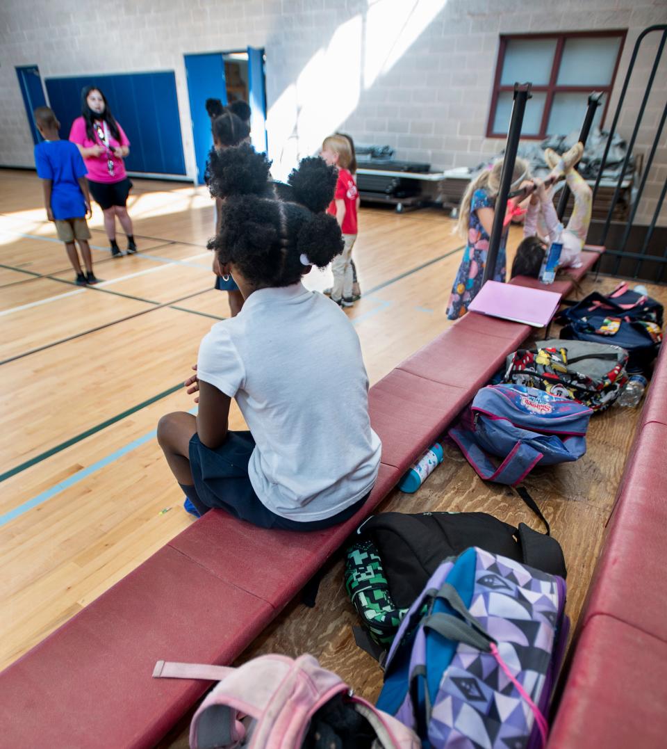 Children wait to be picked up from the YMCA afterschool program at the Vickrey Community Center in Pensacola on Tuesday.