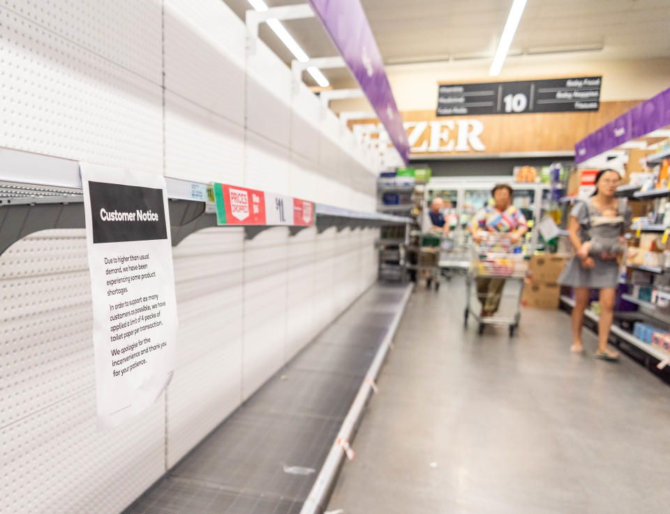 Customers looks at empty shelves at a supermarket in Brisbane.