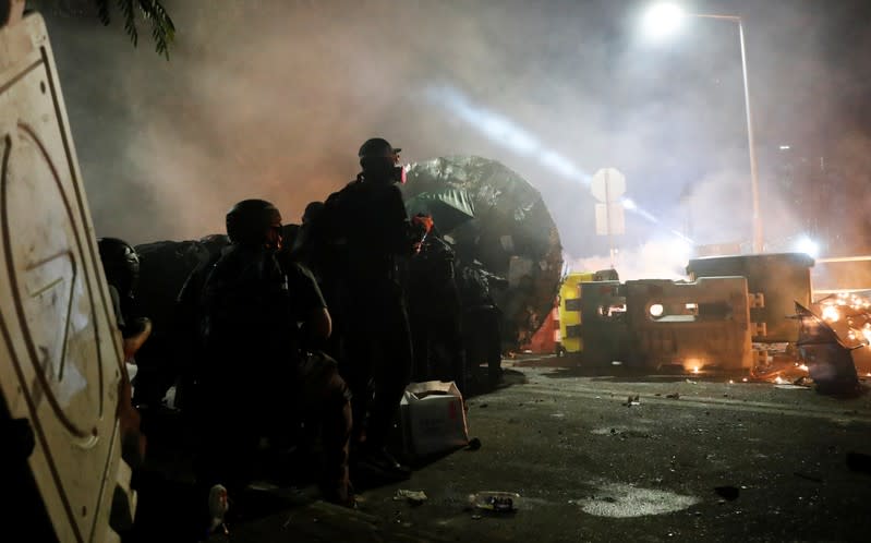 Protesters take cover during a standoff with riot police at the Chinese University of Hong Kong