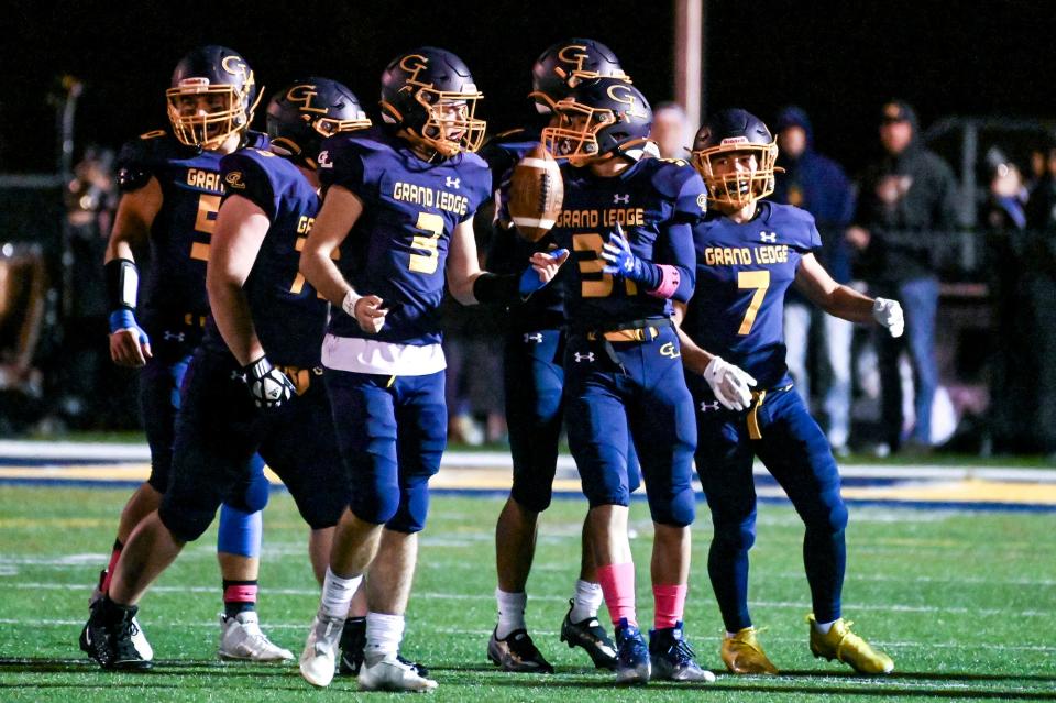 Grand Ledge's Austin Brown, center, celebrates with teammates after recovering an East Lansing fumble during the second quarter on Friday, Oct. 20, 2023, at Grand Ledge High School.