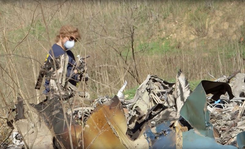 An investigator works at the site of the helicopter crash that killed Kobe Bryant and eight others in a screen grab taken in Calabasas