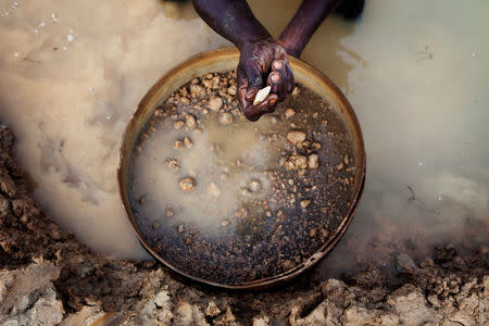 FILE PHOTO: An artisanal miner pans for diamonds in the town of Koidu, in eastern Sierra Leone April 21, 2012. REUTERS/Finbarr O'Reilly/File Photo