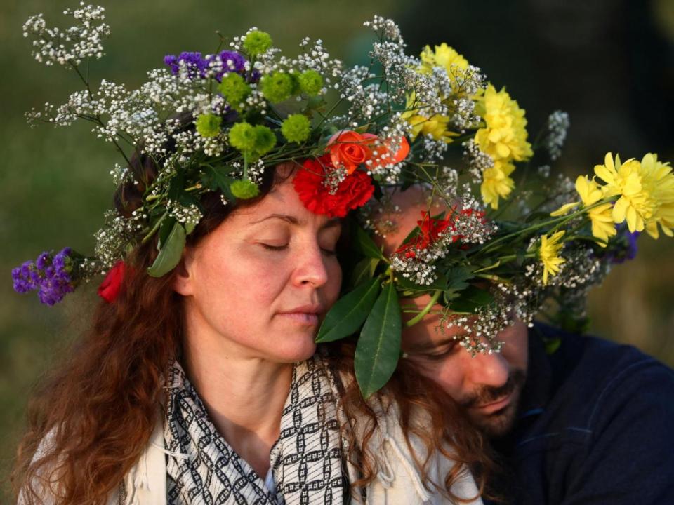 Others wore flower garlands as the sun rose on the late-Neolithic monument (REUTERS)