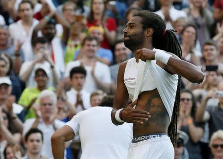 Dustin Brown of Germany pats a tattoo after winning his match against Rafael Nadal of Spain at the Wimbledon Tennis Championships in London, July 2, 2015. REUTERS/Stefan Wermuth