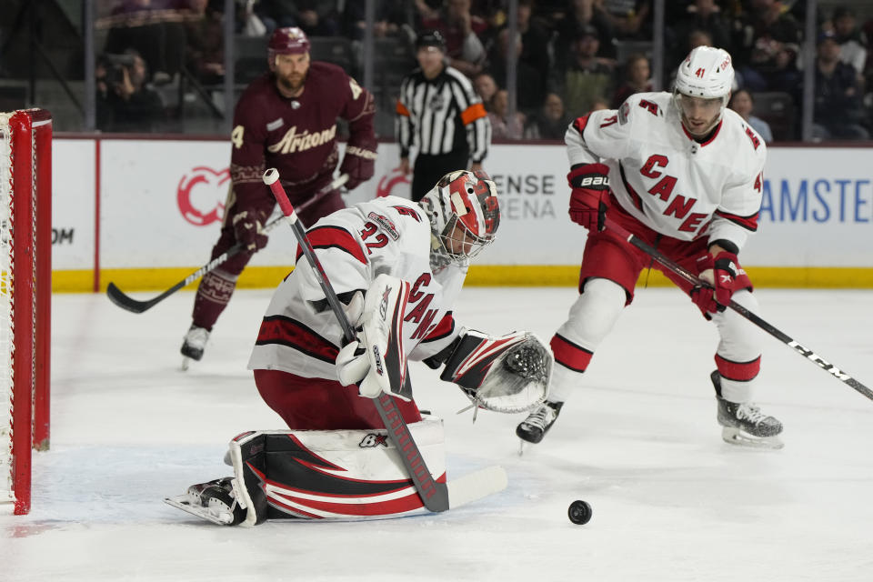 Carolina Hurricanes goaltender Antti Raanta (32) makes a save in front of Hurricanes defenseman Shayne Gostisbehere, right, and Arizona Coyotes right wing Zack Kassian, back left, in the first period during an NHL hockey game, Friday, March 3, 2023, in Tempe, Ariz. (AP Photo/Rick Scuteri)