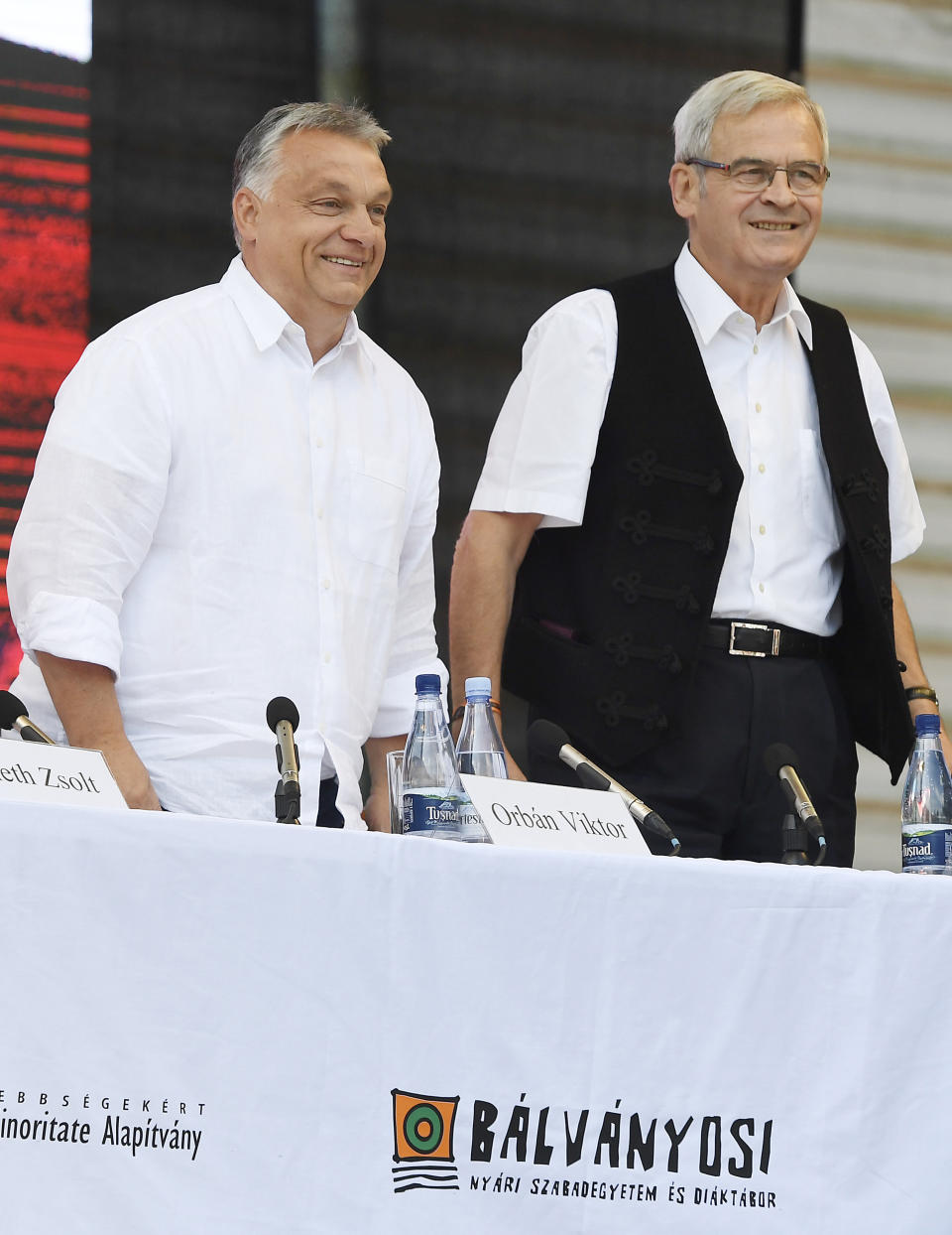 Hungarian Prime Minister Viktor Orban, left, prepares to speak as President of the Hungarian National Council of Transylvania Laszlo Tokes looks on at the 30th Balvanyos Summer University and Students' Camp in Baile Tusnad, Transylvania, Romania, Saturday, July 27, 2019. (Szilard Koszticsak/MTI via AP)