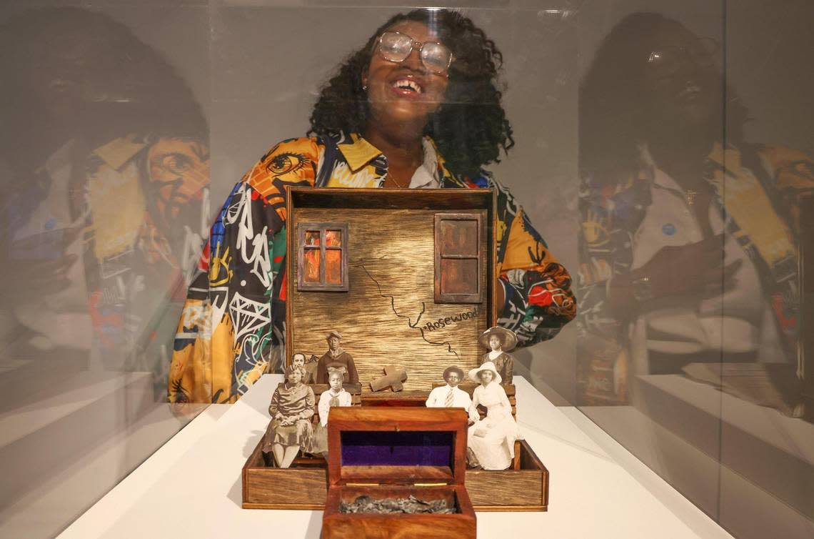 Artist Tori Scott, 24, smiles as she tours the exhibition and reveals her art piece that is part of ‘An Elegy of Rosewood,’ a commemoration of the 100-year anniversary of the Rosewood Massacre presented in photographs, heirlooms and contemporary mixed media art expressions at the Frost Art Museum.