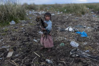 <p>Melinda Quispe walks on the trash-strewn shore of Lake Titicaca in her village of Kapi Cruz Grande, in the Puno region of Peru on Feb. 4, 2017. (Photo: Rodrigo Abd/AP) </p>