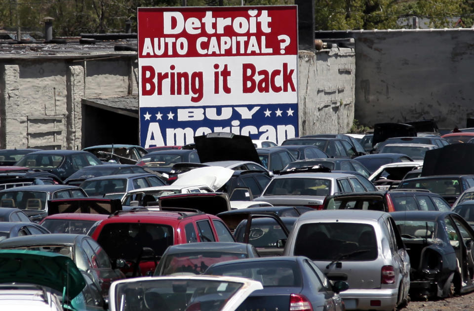 A large 'Buy American' sign, in support of Detroit's auto industry, is seen in the back of an auto scrap yard in Detroit, Michigan May 18, 2009. REUTERS/Rebecca Cook